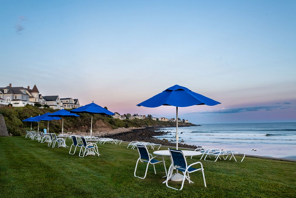 Oceanfront lawn seating overlooking Long Sands Beach at sunset.