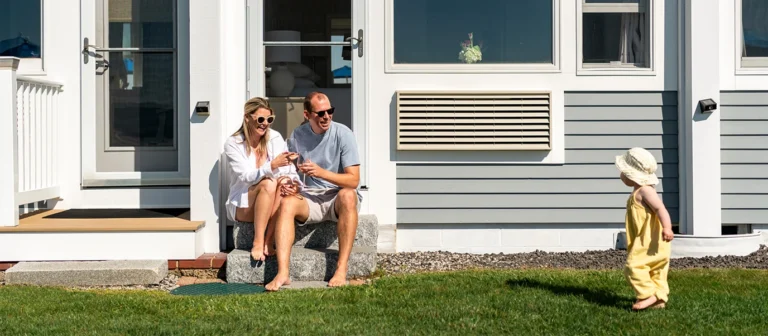 Family relaxing outside an oceanfront guest room with direct lawn access at The Cutty Sark Motel.