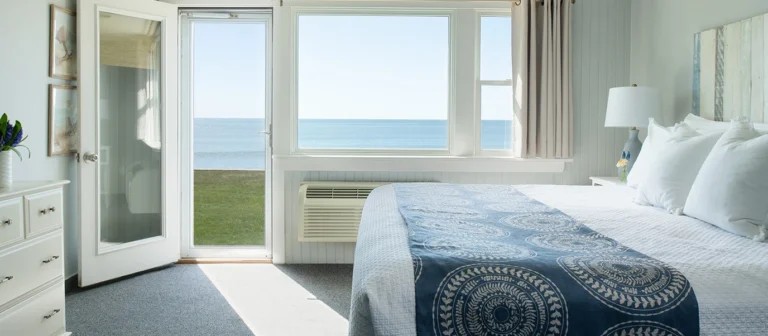 Oceanfront king guest room with direct lawn access and panoramic beach views.