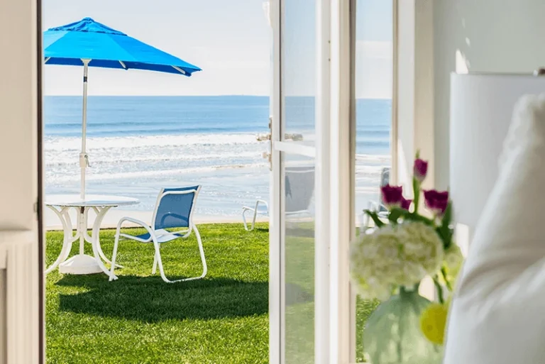 Oceanfront lawn seating outside a lower building first-floor guest room at The Cutty Sark Motel.