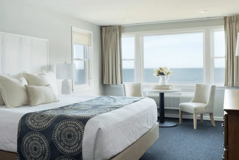 Lower building second- and third-floor king guest room with panoramic ocean views and coastal decor.