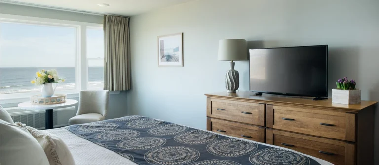 Oceanfront seating area in an upper building second- and third-floor room with panoramic water views and coastal decor.