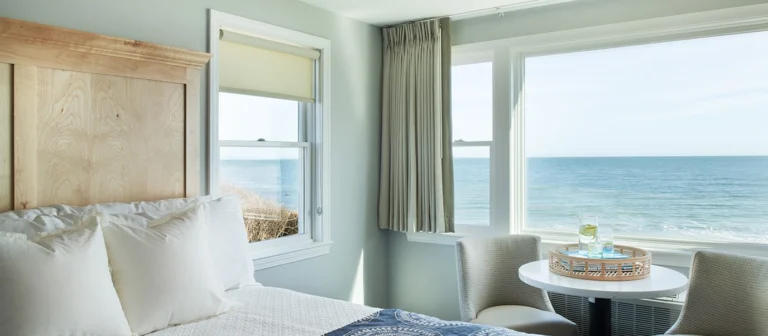 Bright upper building second- and third-floor king room with expansive ocean views and coastal-inspired furnishings.