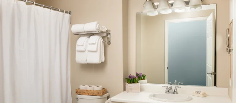 Clean and updated bathroom in an upper building first-floor guest room with fresh towels and bright vanity lighting.